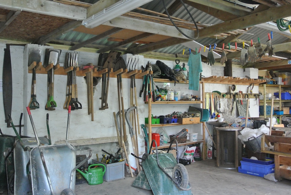 スコップから長靴まで、あらゆる畑道具が整理されている納屋。